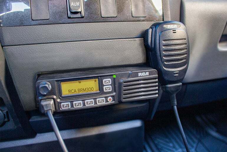 An RCA BRM300D mobile two-way radio is mounted to a vehicle's center console.