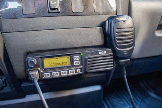 An RCA BRM300D mobile two-way radio is mounted to a vehicle's center console.